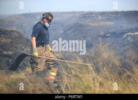 Ein Feuerwehrmann von Tyne und Wear Feuer- und Rettungsdienst setzt heraus das Feuer im Winter Hill in der Nähe von Bolton, als mehr als 20 Löschfahrzeuge sind an der Szene mit Besatzung die Bewältigung der Moorlandschaft Brände. Stockfoto