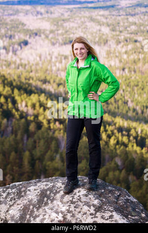 Junge Frau steht auf der Klippe. Stockfoto