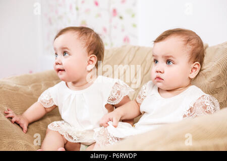 Zwei adorable Baby Zwillinge im Stuhl sitzen.