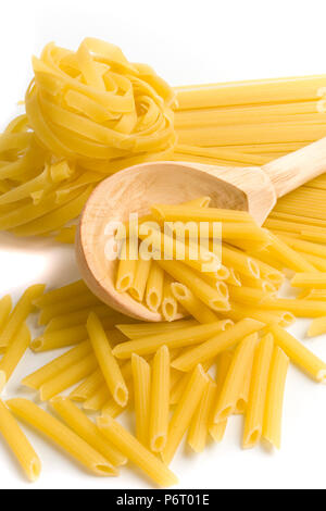 Raw italienische Pasta in hölzernen Löffel auf weißem Hintergrund Stockfoto