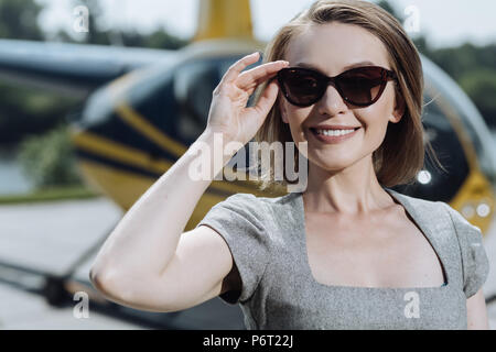 In der Nähe eines charmanten Geschäftsfrau ihre Sonnenbrille einstellen Stockfoto