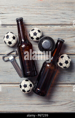 Bier Flasche mit Fußball-Fußball-Kugeln auf einem hölzernen Hintergrund Stockfoto