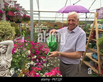 Besitzer des Hillmount Garden Center Robin Mercer, der Blumen gießt, wie ein Schlauchpfeifenverbot in Nordirland einen beispiellosen Ansturm auf einen anderen Gärtner-Freund, die Gießkanne, ausgelöst hat. Dosen aller Formen und Größen sind in der ganzen Region aus den Regalen geflogen, da Gärtner sich arbeitsintensiveren Mitteln zuwenden, um ihre Pflanzen und Rasenflächen mit Feuchtigkeit zu versorgen. Stockfoto