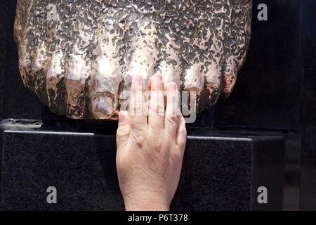 Woman's Hand auf Statue Stockfoto