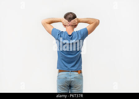 Mann im blauen Hemd mit geschlossenen Ohren zurück zur Kamera drehen. Stockfoto