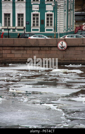 Eisschilde auf dem Fluss Newa mit einem nicht-Anker-Verbotsschild auf der Kaimauer (unscharf) in St. Petersburg, Russland Stockfoto