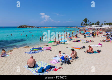 Touristen Sonnenbaden am Nissi Beach in der Nähe von Ayia Napa, Zypern Stockfoto