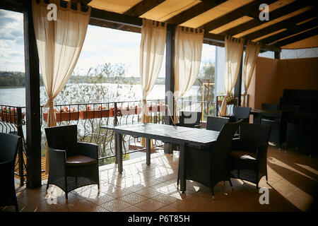 Offene Terrasse in einem leeren Sommer Cafe mit Blick auf den Fluss Stockfoto