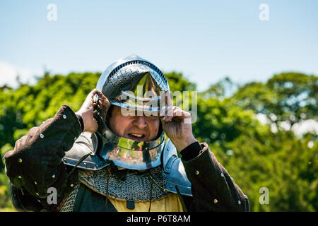 Andrew Spratt in mittelalterlichen Rüstungen und Knight's Helm im Sprechen über mittelalterliche Waffen von Historic Scotland, dirleton Castle, East Lothian, Schottland, Großbritannien Stockfoto