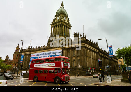 LEEDS, England - Juni 6, 2018: Classic Red deutsch-Bus mit zwei Etagen und der Leeds Rathaus im Hintergrund, während Sie im bewölkten Tag. Stockfoto