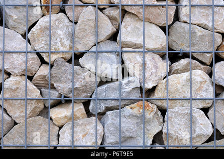 Gabionen Wand mit gebrochener Kalkstein Felsen im Käfig aus Metall Stockfoto