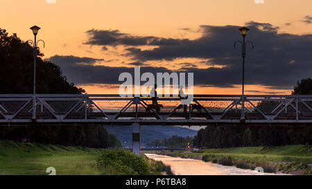 Liebe Brücke in Pirot bei Sonnenuntergang und Silhouetten von 2 Mädchen mit Hunden Stockfoto