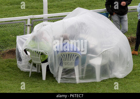 Hamburg, die Zuschauer sitzen im Regen unter einer Plastikplane, an ihrem Tisch auf der Flucht Stockfoto