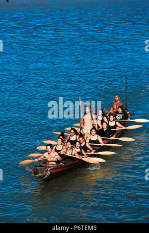 Maori Männer und Frauen paddeln traditionellen Waka (Kanu) in Waitangi, Neuseeland Stockfoto