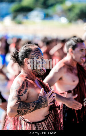 Furchterregende Maori Warriors mit Gesichts moko Tätowierungen durchführen Kapa Haka auf Waitangi Day in Waitangi, Neuseeland Stockfoto