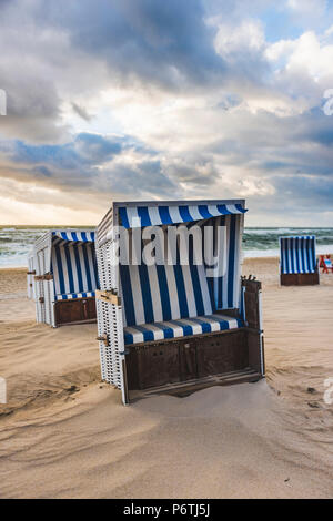 Kampen, Sylt, Nordfriesland, Schleswig-Holstein, Deutschland. Strandkorbs am Strand bei Sonnenuntergang. Stockfoto