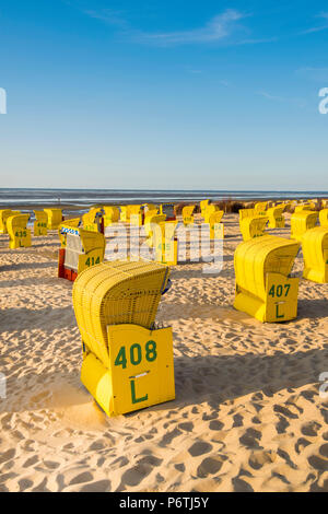 Duhnen, Cuxhaven, Niedersachsen, Deutschland. Gelbe Strandkorbs entlang des Wattenmeeres. Stockfoto