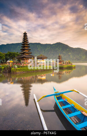 Bali, Indonesien, Südostasien. Der Pura Ulun Danu Bratan wasser Tempel und einem traditionellen Indonesischen Kanu (cadik oder jukung) auf dem See Bratan vertäut. Stockfoto