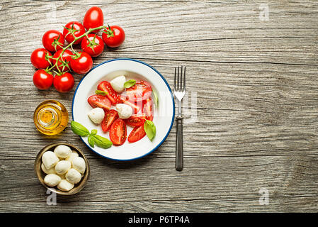 Frische Tomaten und Mozzarella auf Holz- Hintergrund. Ansicht von oben Stockfoto