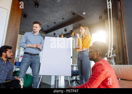 Gruppe der multirassischen Freunde denken über Route von Ihrem Fahrrad reiten Reise durch die Vor einem Flipchart im modernen Klassenzimmer Stockfoto