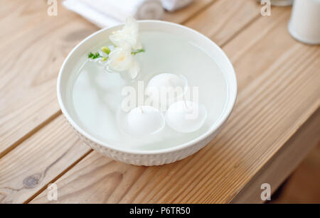 Spa mit Kerzen in Aromabad und gerollte Handtücher auf den Holztisch. Stockfoto
