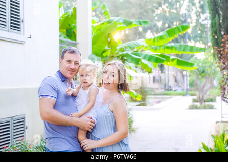 Glückliche Familie von drei - schwangere Mutter, Vater und Tochter umarmen, Lachen, Spaß in der Sunset Park. Familie Erholung, Zeit bereitgestellt Stockfoto