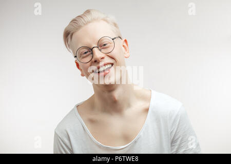 Gerne blonde Mann mit ungewöhnlichen stattliches Aussehen zufrieden lächelnd in die Kamera in Träumen Ausdruck mit kommenden Feiertage glücklich zu werden. Stockfoto