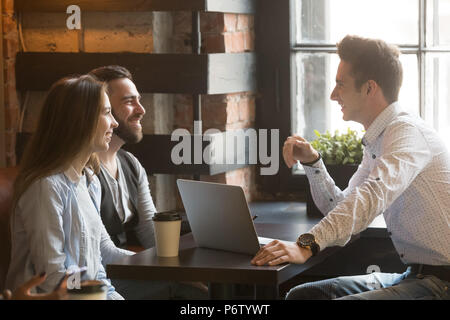 Männliche Architekt consulting aufgeregt tausendjährigen Paar in Kaffee sh Stockfoto