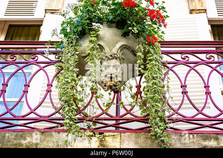 Keramik hängenden Korb voller Blumen mit Gehörnten satyr Skulptur in Beaune, Burgund, Frankreich am 23. Juni 2018 getroffen Stockfoto