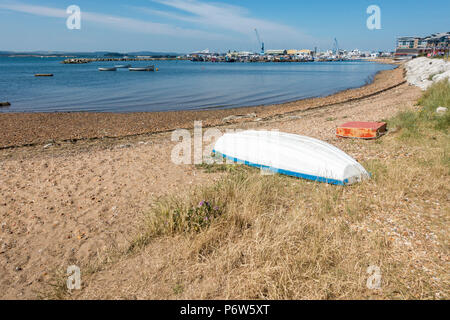 Blick auf den Hafen von Poole und Strand mit einem umgedrehten Boot auf dem Sand an einem Sommertag im Jahr 2018, Dorset, Großbritannien Stockfoto