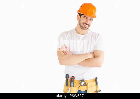 Porträt der jungen Handwerker tragen, hart, Hut und Gürtel beim Stehen mit den Armen an vereinzelten weißen Hintergrund gekreuzt. Stockfoto