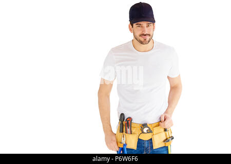 Portrait von hübscher junger Handwerker tragen Baseball Cap und Werkzeug Gürtel beim Stehen an vereinzelten weißen Hintergrund mit kopieren. Stockfoto