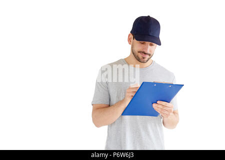 Portrait von gutaussehenden jungen Mann an vereinzelten weißen Hintergrund. Ein Lächeln auf den Lippen tragen Mann Baseballmütze und Holding Zwischenablage in seiner Hand. Stockfoto