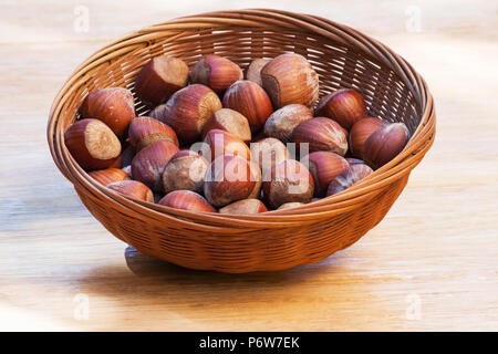 Haselnüsse in einem Korb auf einem Holztisch Stockfoto