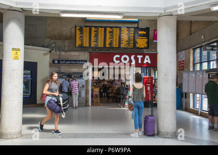 Im Ticket Office in Guildford Bahnhof, mit einem Costa Coffee Shop und Passagiere Tickets kaufen von SB-Automaten, Surrey, Großbritannien Stockfoto