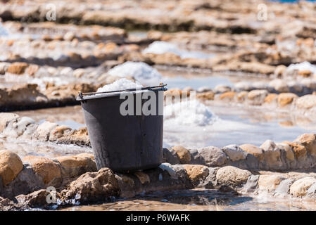 Ernte Meersalz aus dem alten Salinen in Marsalforn, Gozo, Malta. Stockfoto