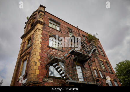 Rochdale Road Sudell Straße Collyhurst Terrakotta Gebäude aus rotem Backstein mit Brettern vernagelt unbesetzt isoliert ehemalige Wohnhaus nur diese Ecke Abschnitt Stockfoto