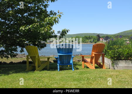 Eine Reihe von bunten Adirondack Stühle zum Entspannen und den Blick auf die Küstenlinie in Annapolis Royal, Nova Scotia bewundern. Stockfoto