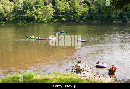 Eine Gruppe von Menschen, Kajakfahren und genießen sitzen durch den Allegheny River in Althom, Pennsylvania, USA an einem Sommertag. Stockfoto