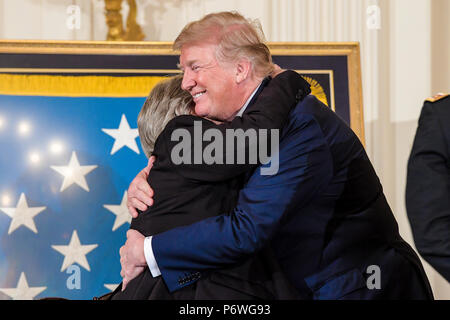 Präsident Donald J. Trumpf umfasst Pauline Lyda Brunnen Conner, der ehegatte der US Army 1st Lieutenant Garlin M. Conner, während einer Zeremonie im Weißen Haus in Washington, D.C., 26. Juni 2018. Conner wurde posthum die Ehrenmedaille für Maßnahmen vergeben, während als Nachrichtenoffizier mit Hauptsitz und Sitz der Gesellschaft, 3. Battalion, 7th Infantry Regiment, 3 Infanterie Division, während des Zweiten Weltkriegs am Jan. 24, 1945. (U.S. Armee Foto von SPC. Anna Pol) Stockfoto