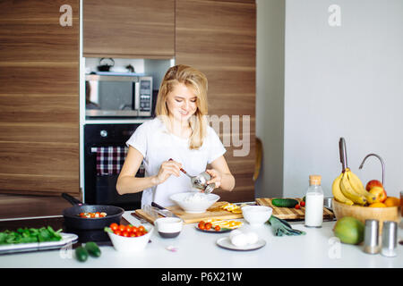 Frau, die gesunden Salat von frischem Gemüse, Halteplatte mit Cherry Tomaten und Spinat. Pfanne mit gebratenem Hühnchen kebab Stand auf der Stockfoto