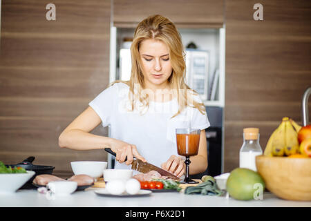 Frau schneiden Fleisch Zubereitung von Fleisch Kebab auf einem Tisch mit einem großen Kochmesser. Attraktive kochen Schneiden von Fleisch auf den Tisch bereitet Sie Boyfr zu überraschen Stockfoto