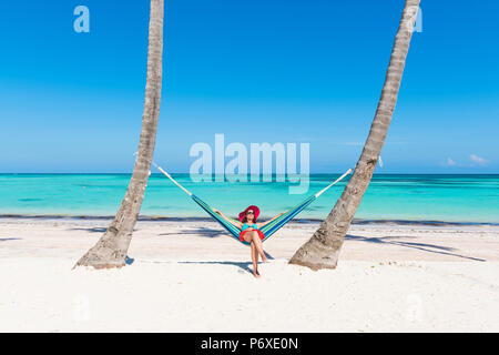 Juanillo Beach (playa Juanillo), Punta Cana, Dominikanische Republik. Frau entspannen auf einer Hängematte am Strand (MR). Stockfoto