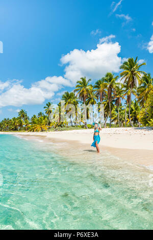 Canto de la Playa, Saona, East National Park (Parque Nacional del Este), Dominikanische Republik, Karibik. Schöne Frau auf einer von Palmen gesäumten Strand (MR).