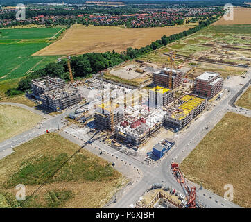 Große Baustelle am Stadtrand hinter einem Dorf mit Wiesen und Felder vor, Luftaufnahme, mit Drone gemacht Stockfoto