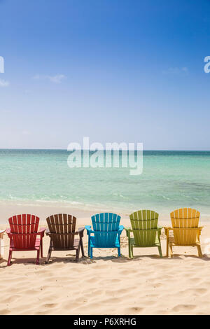 Karibik, Niederländische Antillen, Aruba, eine Reihe von bunten Holzliegen am Palm Beach Stockfoto