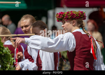 RIGA, Lettland - 22. JUNI 2018: die Sommersonnenwende. Eine junge Frau in einer Tracht gekleidet, mit ein Zeiger auf eine interessante Aussicht. Stockfoto