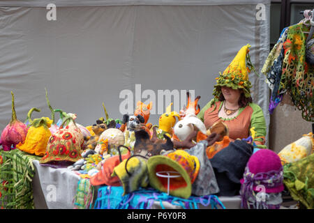 RIGA, Lettland - 22. JUNI 2018: die Sommersonnenwende. Eine Frau in einer Baumwolle - farbige hat zu spüren ist Verkauf von Handgefertigten weichen Filz Spielzeug. Stockfoto