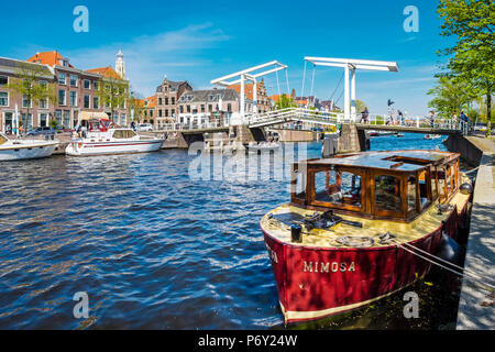 Niederlande, Nordholland, Haarlem. Gravestenenbrug Zugbrücke und Boote auf dem Fluss Spaarne. Stockfoto