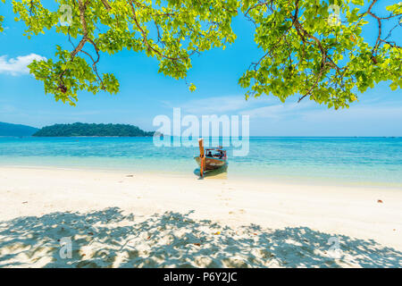 Ko Lipe, Satun Thailand. Traditionelle long tail Boot auf einen leeren Strand vertäut. Stockfoto